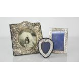 Three silver picture frames including a Victorian example embossed with cherubs, 16 by 14cm.