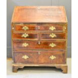 An early 18th century George II walnut veneered bureau, with five cross banded oak lined drawers,