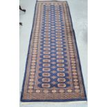 A 19th century dark blue runner, decorated with stylised motifs, 250 cm by 81cm wide.