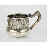 A sterling silver cup, embossed with fruits and flowers, with a shaped handle, 2.48toz.