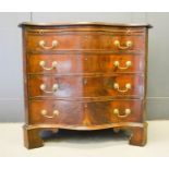 A late 19th century mahogany serpentine bachelors chest, with brush slide, fret carved decoration