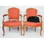 A pair of late 19th / early 20th century French armchairs, raised on cabriole legs, upholstered in