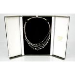 An 18ct white gold, seven strand diamond set necklace, with thirty five individual collet set