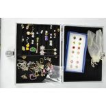 A jewellery case containing a collection of earrings, of various design, mostly silver.
