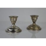 A pair of sterling silver candlesticks, with weighted bases, 8cm high.