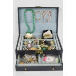 A jewellery box containing costume jewellery such as brooches, rings, necklaces and bracelets.