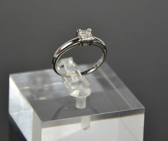 A platinum and diamond ring, set with four princess cut diamonds totalling 0.25cts, size O½, 4.4g.