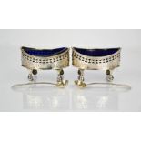 A pair of silver and blue glass lined mustard pots, London 1805, oval form, pierced and engraved