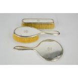 An Asprey & Co Ltd. silver dressing table set comprising clothes brush, hand mirror and hairbrush,