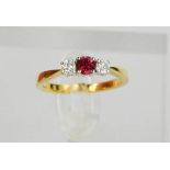 An 18ct yellow gold, diamond and garnet trilogy ring, the central garnet flanked by diamonds, size