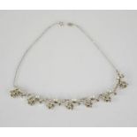 A 1930s paste / diamante necklace, composed of flowerheads, 41cm long.