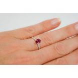 A 14ct white gold and and ruby ring, the 1ct oval cut ruby and approximately 0.10ct diamond in