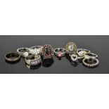 A group of silver rings, of various style, including cluster rings and solitaires.