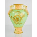 A Royal Worcester twin handled vase, with green ground and gilded decoration. 27cms
