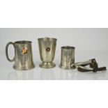 Three pewter tankards and a pair of spurs.