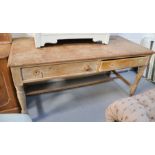 An antique pine kitchen table, with two drawers, raised on turned legs.