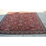 A large carpet in red, green and cream, 300 by 300cm.