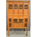 A large Chinese cabinet, with shelved interior, and pierced doors.