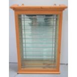 A pine mirror backed display cabinet with glass shelves