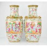 A pair of 19th century Chinese Canton vases, depicting figural scenes, and modelled with gilded lion
