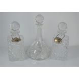 Three cut glass decanters with sterling silver labels