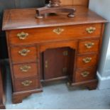A George III desk, in mahogany with banks of drawers either side, secretaire drawer above and a