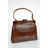 A vintage crocodile skin handbag, with gilt metal and enamel clasp, 21cm high.