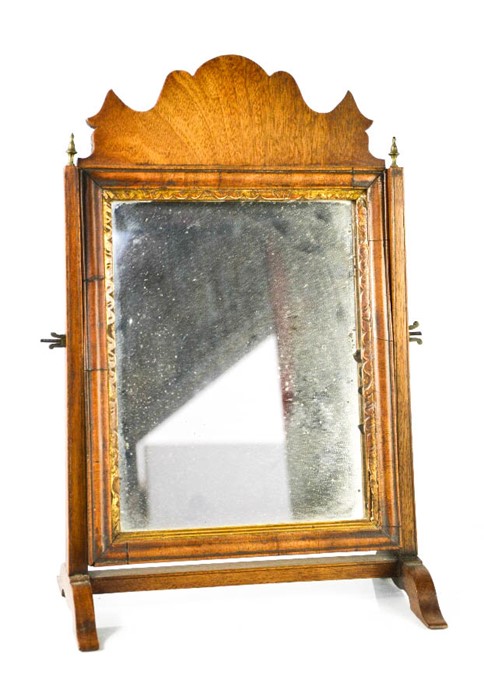 A Georgian mahogany toilet mirror, with shaped top and the original mirror with carved and gilded