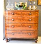 A Victorian mahogany chest of drawers, with two short and three long drawers, raised on bun feet.