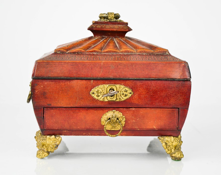 A Regency work box clad in red leather, with fitted interior containing sewing accessories, above