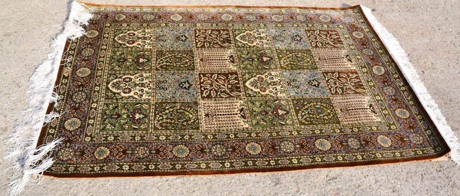 A wool rug with a green ground.