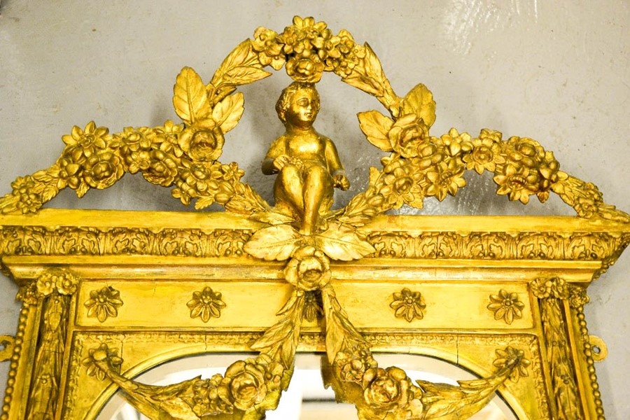 A 19th century ornate gilded mirror, modelled with a cherub beneath floral garlands to the top, - Image 2 of 3