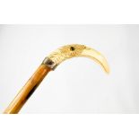A 19th century walking stick with an ivory carved handle in the form of a birds head, inset with