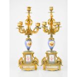 A pair of 19th century French five branch candelabras, with porcelain panels and porcelain bodies