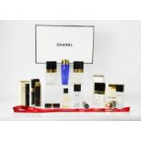 A group of Chanel boxes, bottles, atomiser, lipstick cases, ribbon and Estee Lauder make up remover.