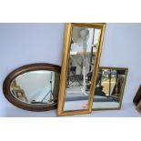 Three wall mirrors, a rectangular gold painted hall mirror, an oval mahogany mirror and a further