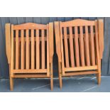 A pair of folding beech garden armchairs.