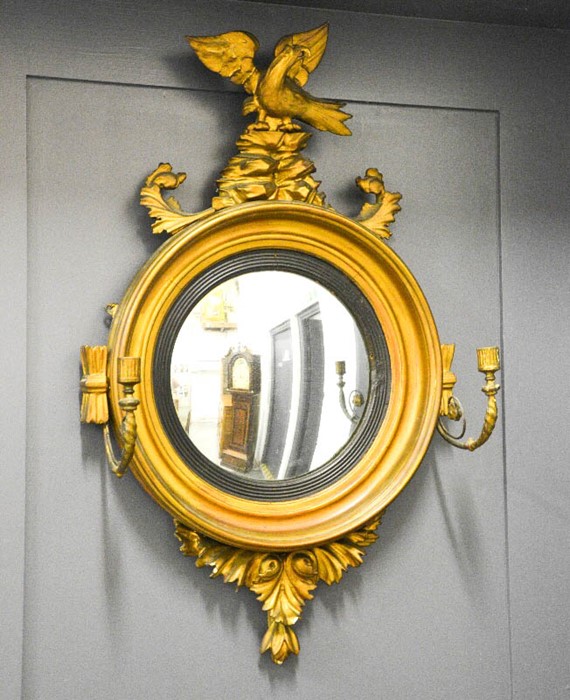 A Regency convex mirror with an eagle modelled to the top, and two candle branches to the front.