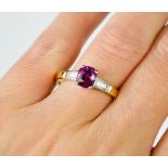 An 18ct yellow gold pink cushion cut sapphire ring, approximately 1.5ct flanked by two trapezoid cut
