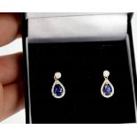 An 18ct white gold blue sapphire pear shape earrings surrounded by diamonds
