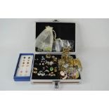 A jewellery box containing rings, earrings, necklaces, loose stones and bracelets.