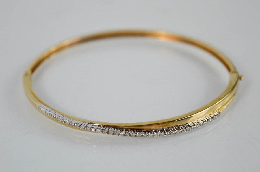 A 9ct yellow gold diamond set bangle - 7.6g