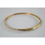 A 9ct yellow gold diamond set bangle - 7.6g