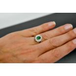 An 18ct white gold and tsavorite garnet and diamond ring, the tsavorite approximately 1.10ct, the