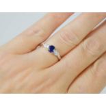 An 18ct white gold blue sapphire and pear shaped diamond trilogy ring, the sapphire approximately