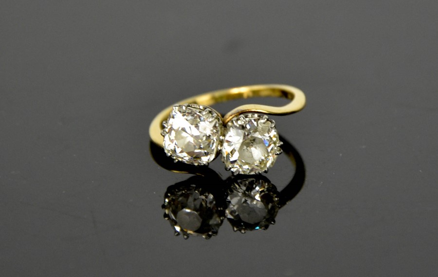 An 18ct gold 'Toi et Moi' diamond crossover ring, set with two large diamonds, each approximately