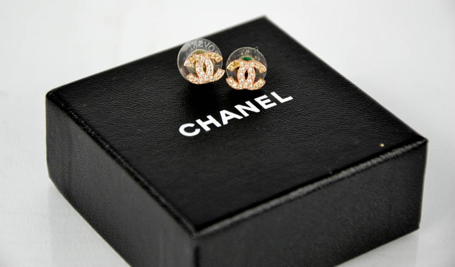 A pair of rose gold coloured and diamante Chanel stud earrings in the original box