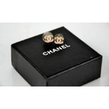 A pair of rose gold coloured and diamante Chanel stud earrings in the original box