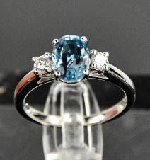 An 18ct white gold, aquamarine and diamond ring, the 1.20ct aquamarine flanked by 0.20cts diamonds