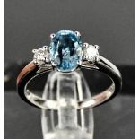 An 18ct white gold, aquamarine and diamond ring, the 1.20ct aquamarine flanked by 0.20cts diamonds